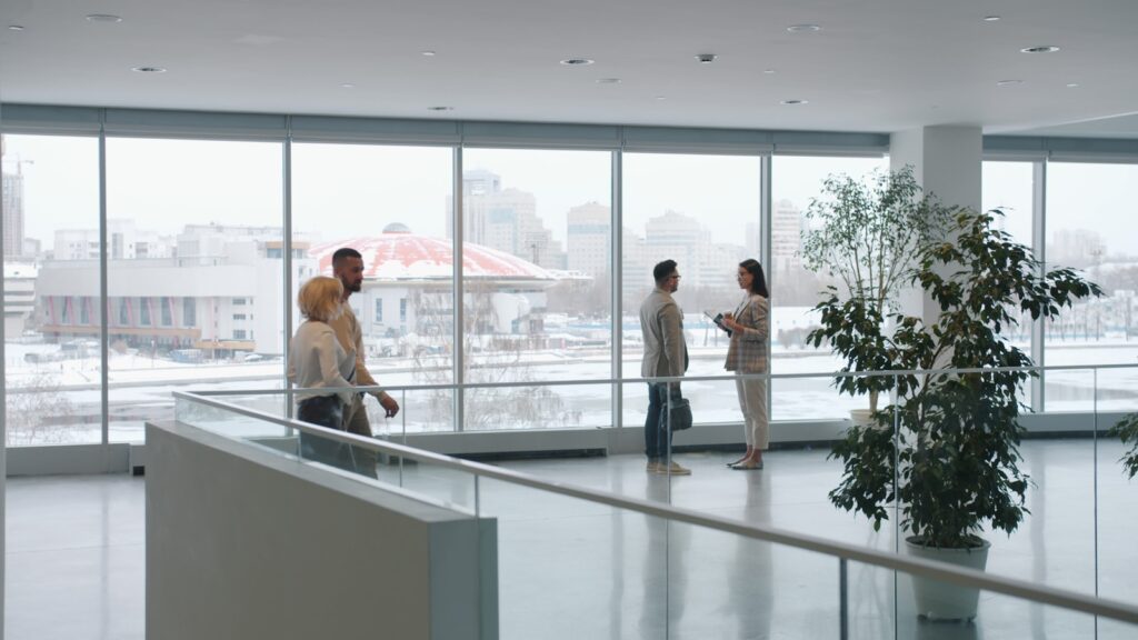 Visitors and employees moving through a bright office lobby